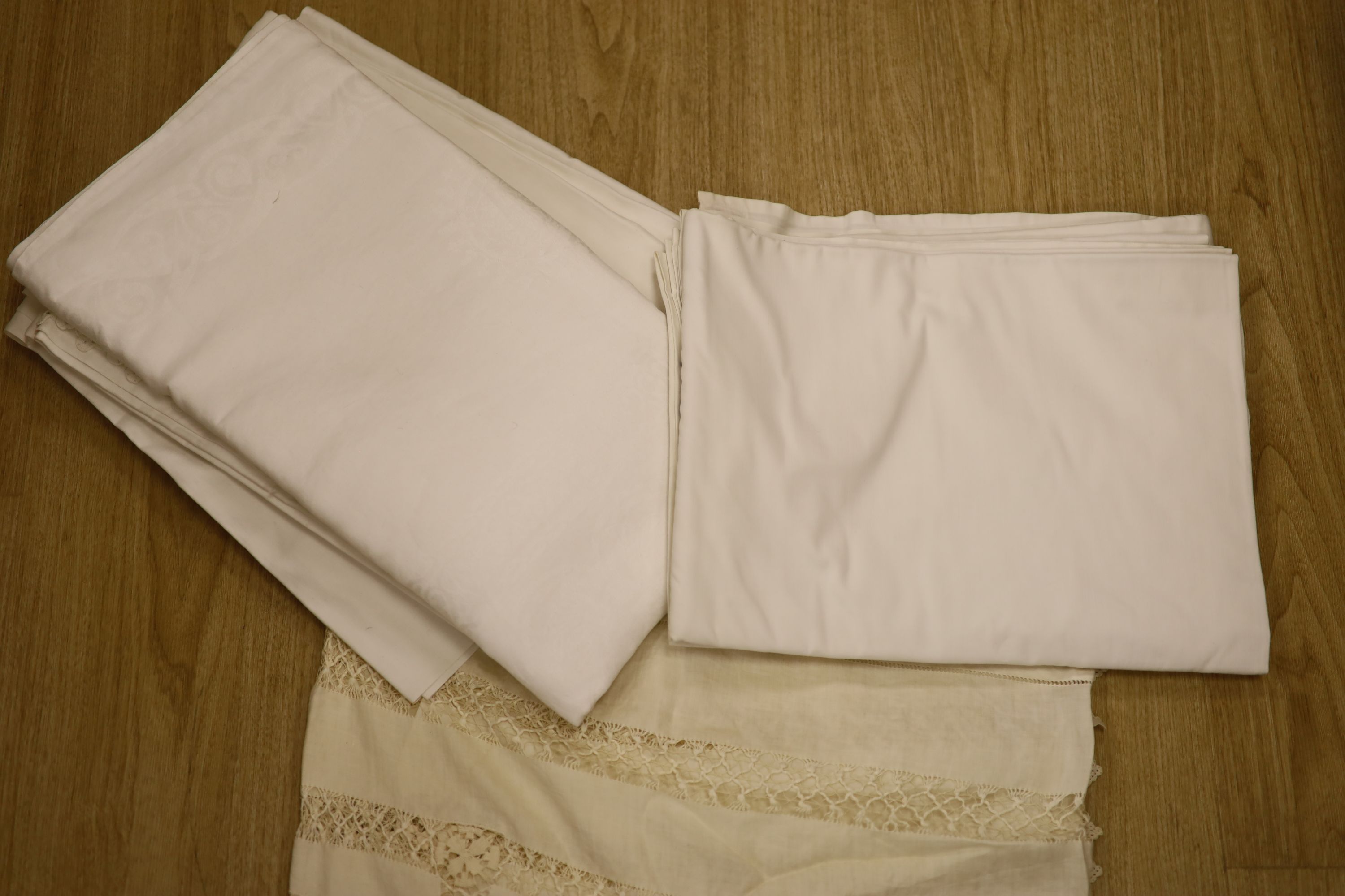 A quantity of linen, including a drawn thread cloth, crochet-edged cloths, damask and sheets